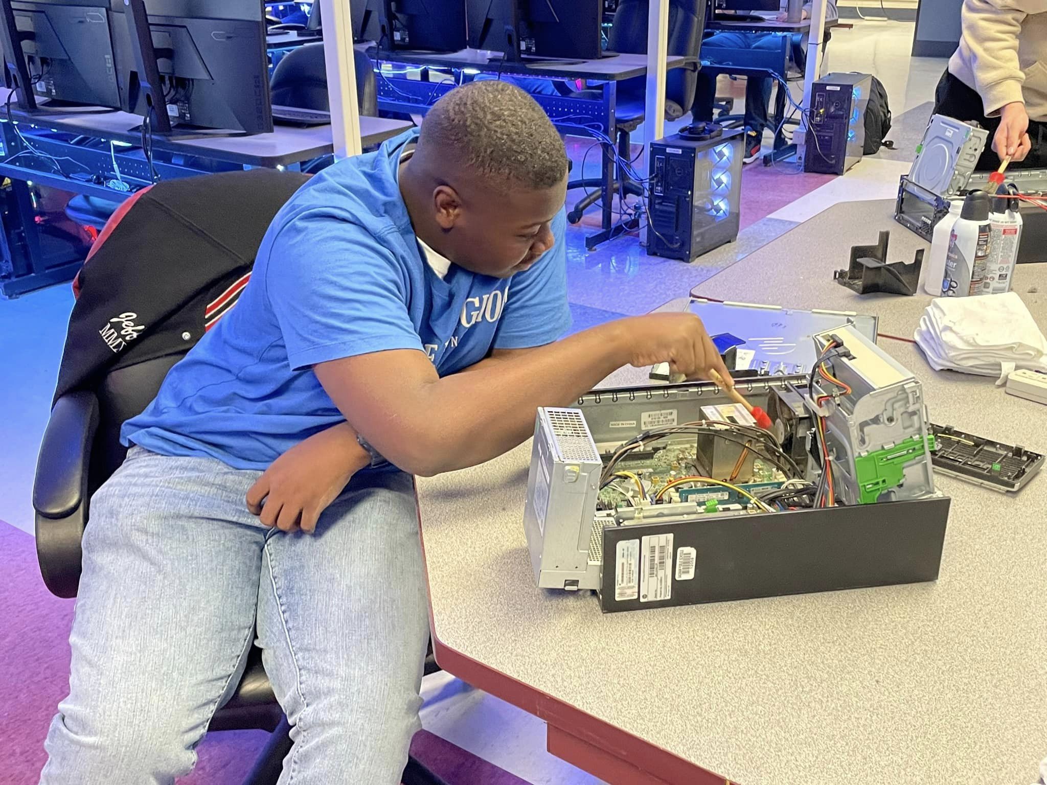 student working on the insides of a computer