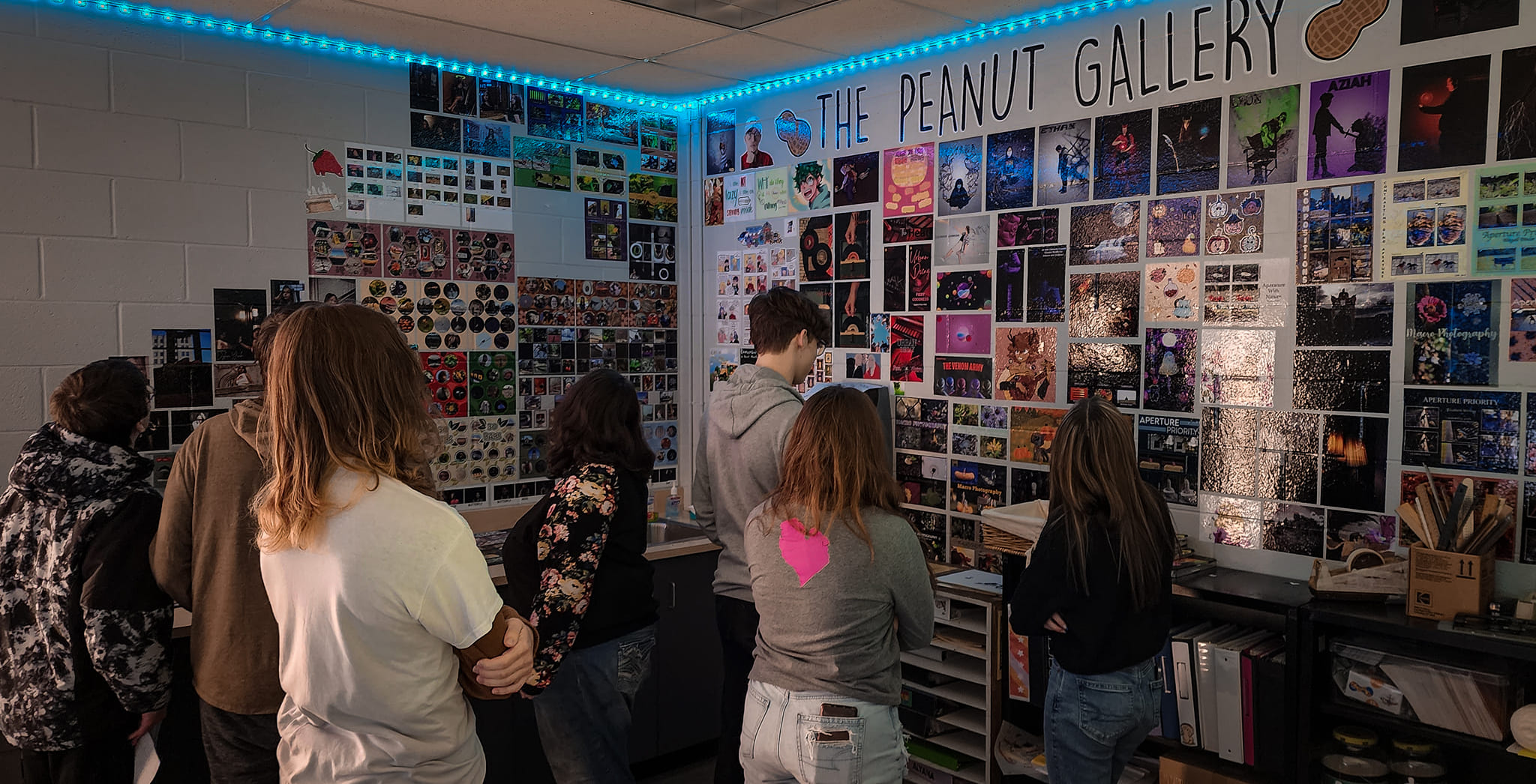 students looking at a wall of pictures