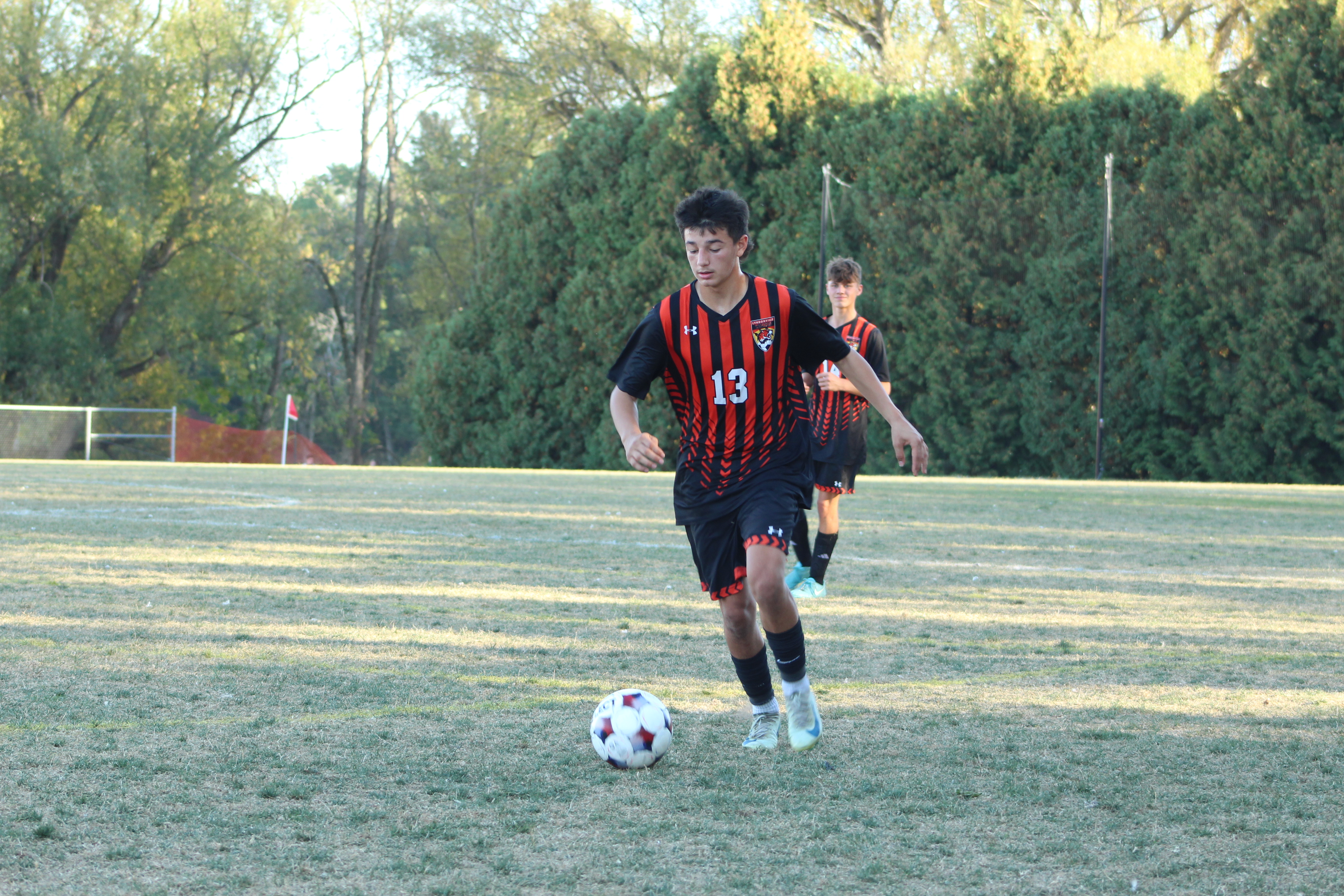 boys playing soccer on field