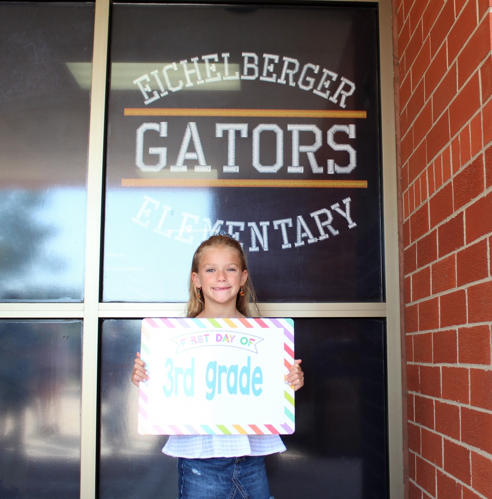 student showing sign to camera