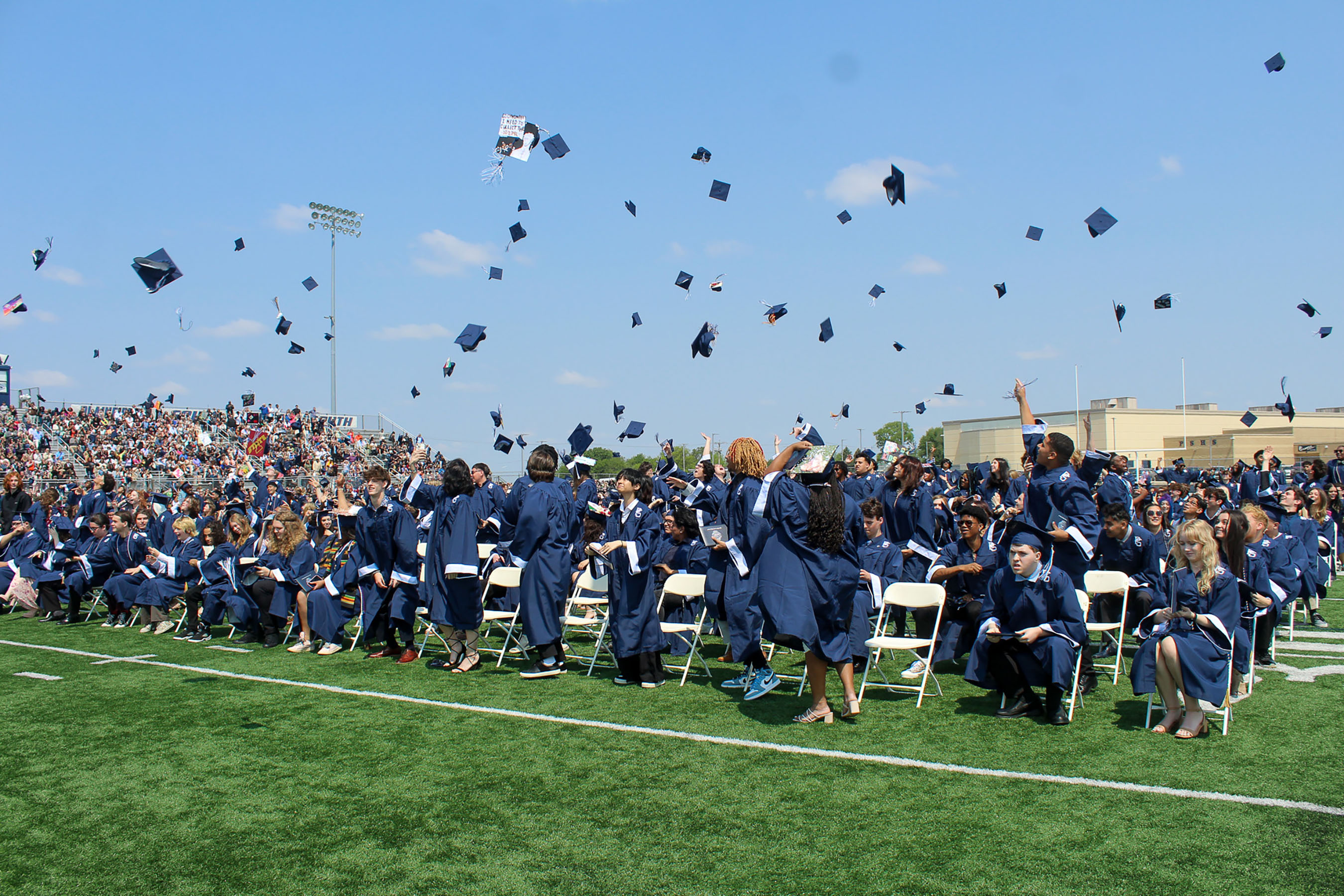 graduates throw caps in air