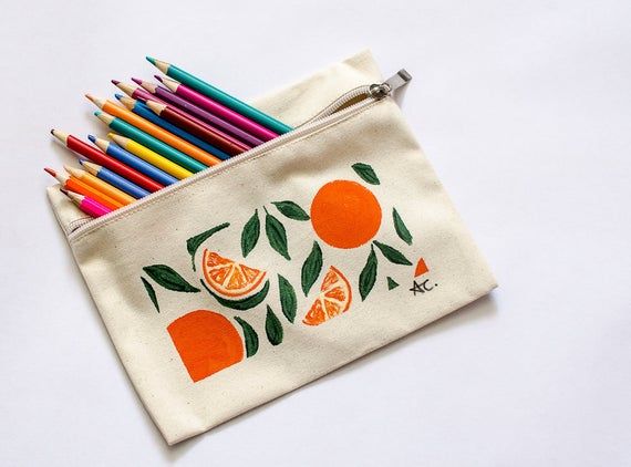 Ecru colored fabric pencil case painted with orange and yellow citrus fruit