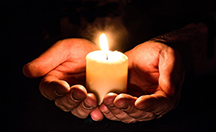 Lit candle on top of cupped hands