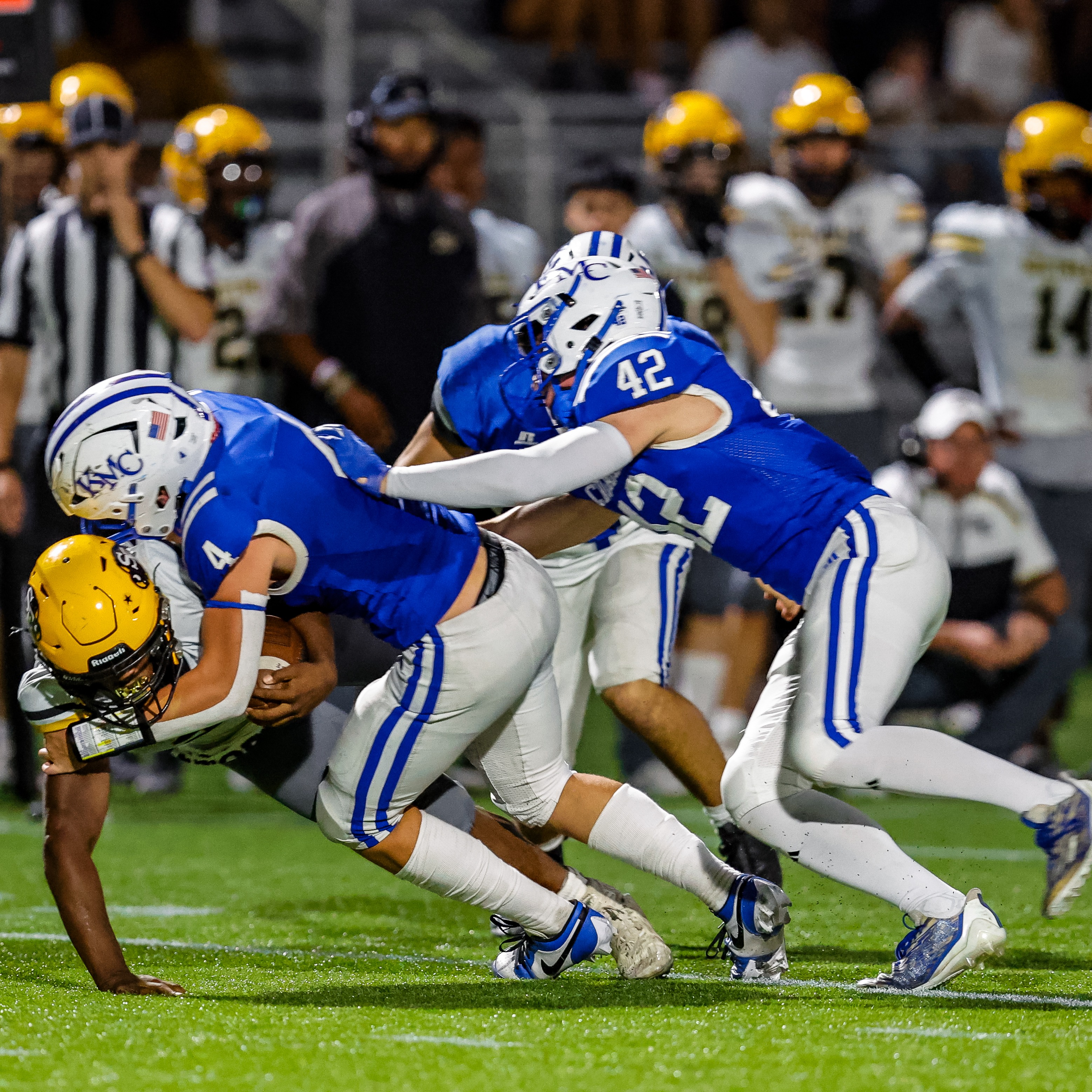 Football players tackle opponent