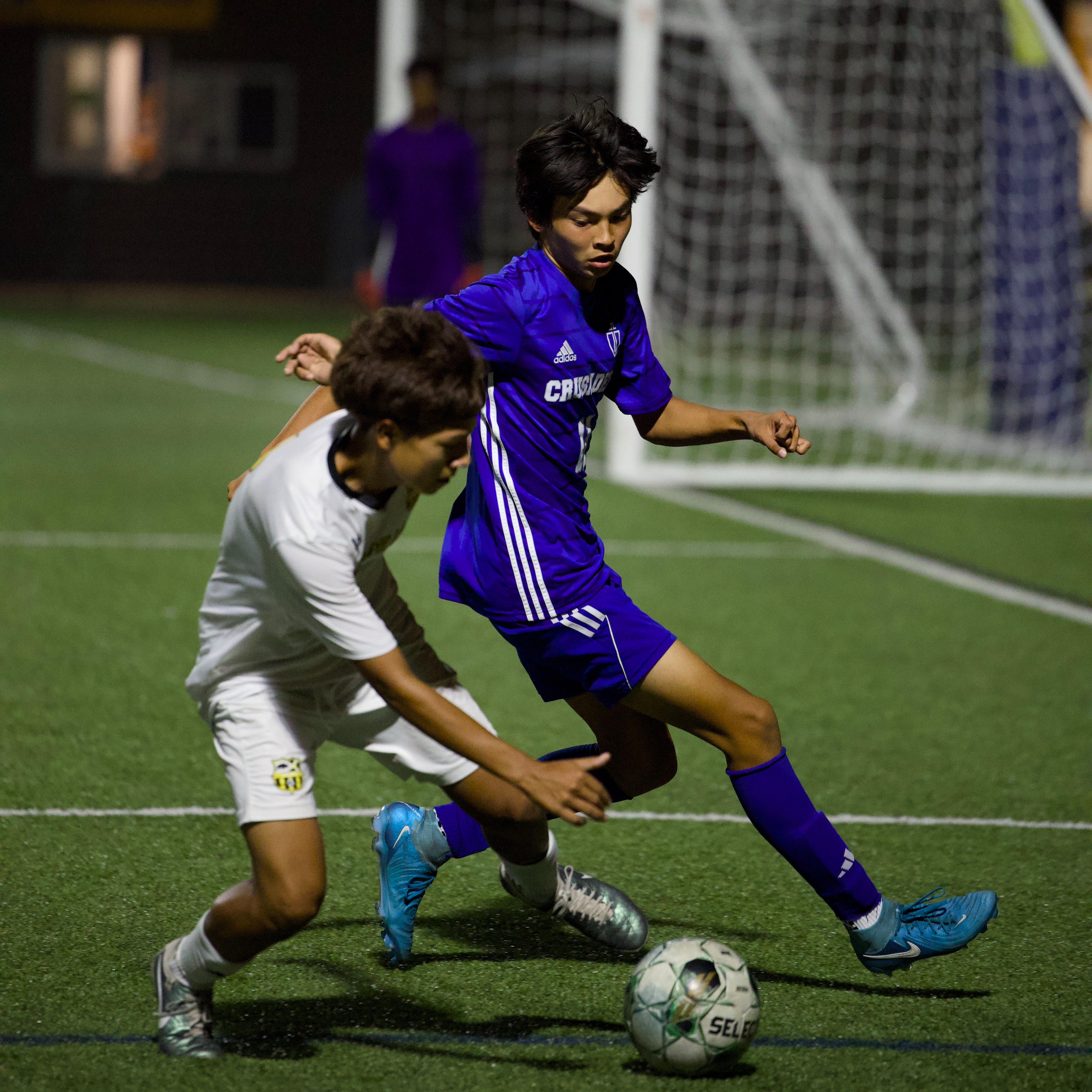 Soccer player fighting opponent for ball