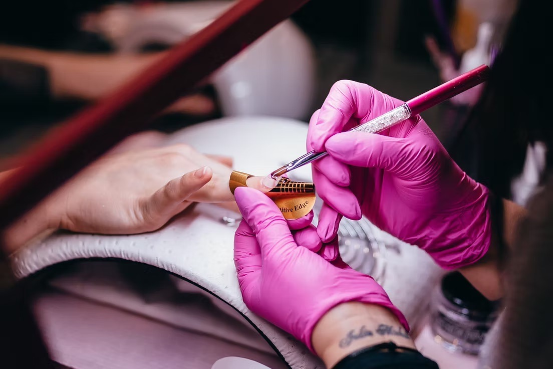 Manicurist giving a manicure to a client.