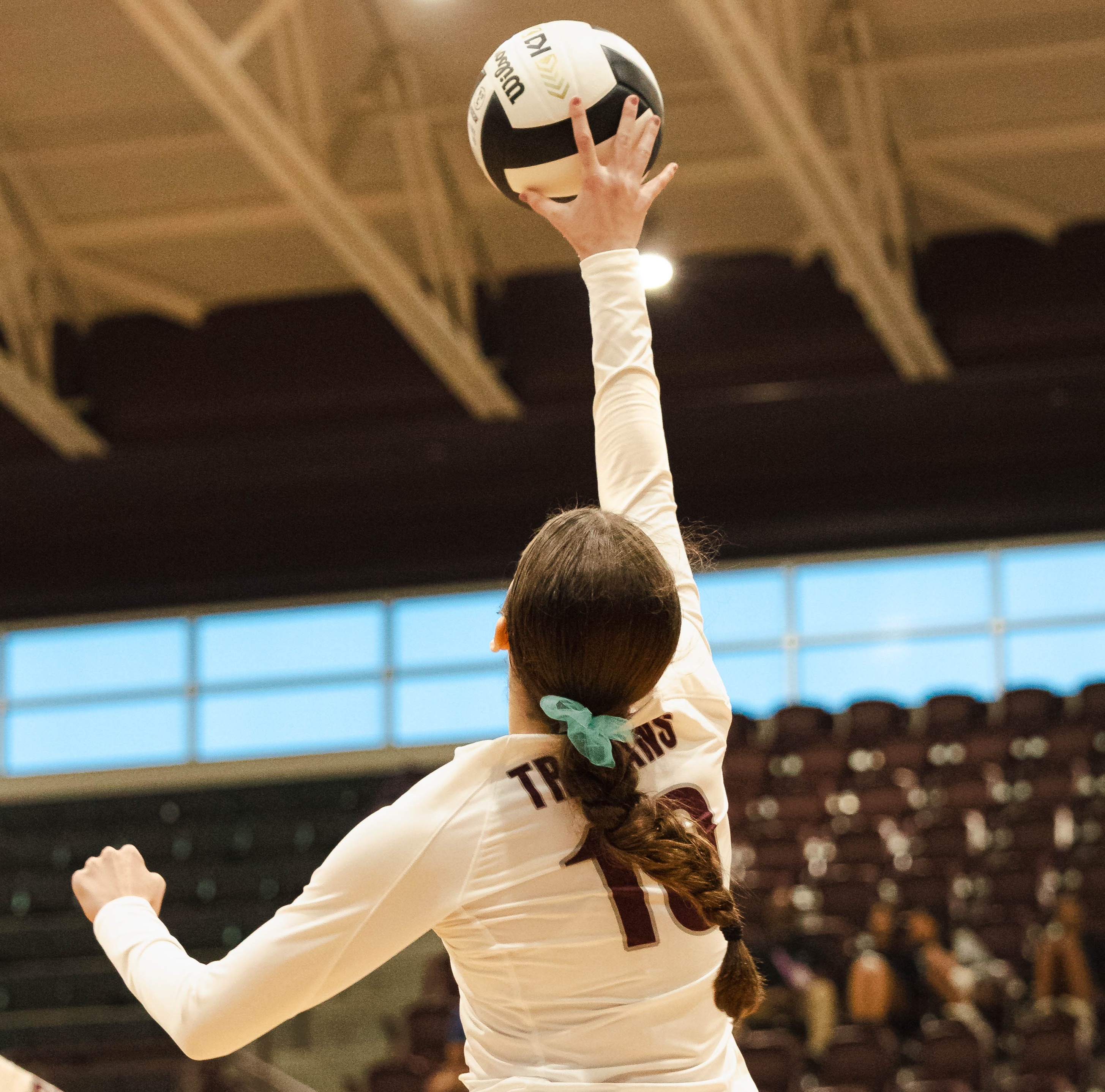 girl hitting volleyball over the net