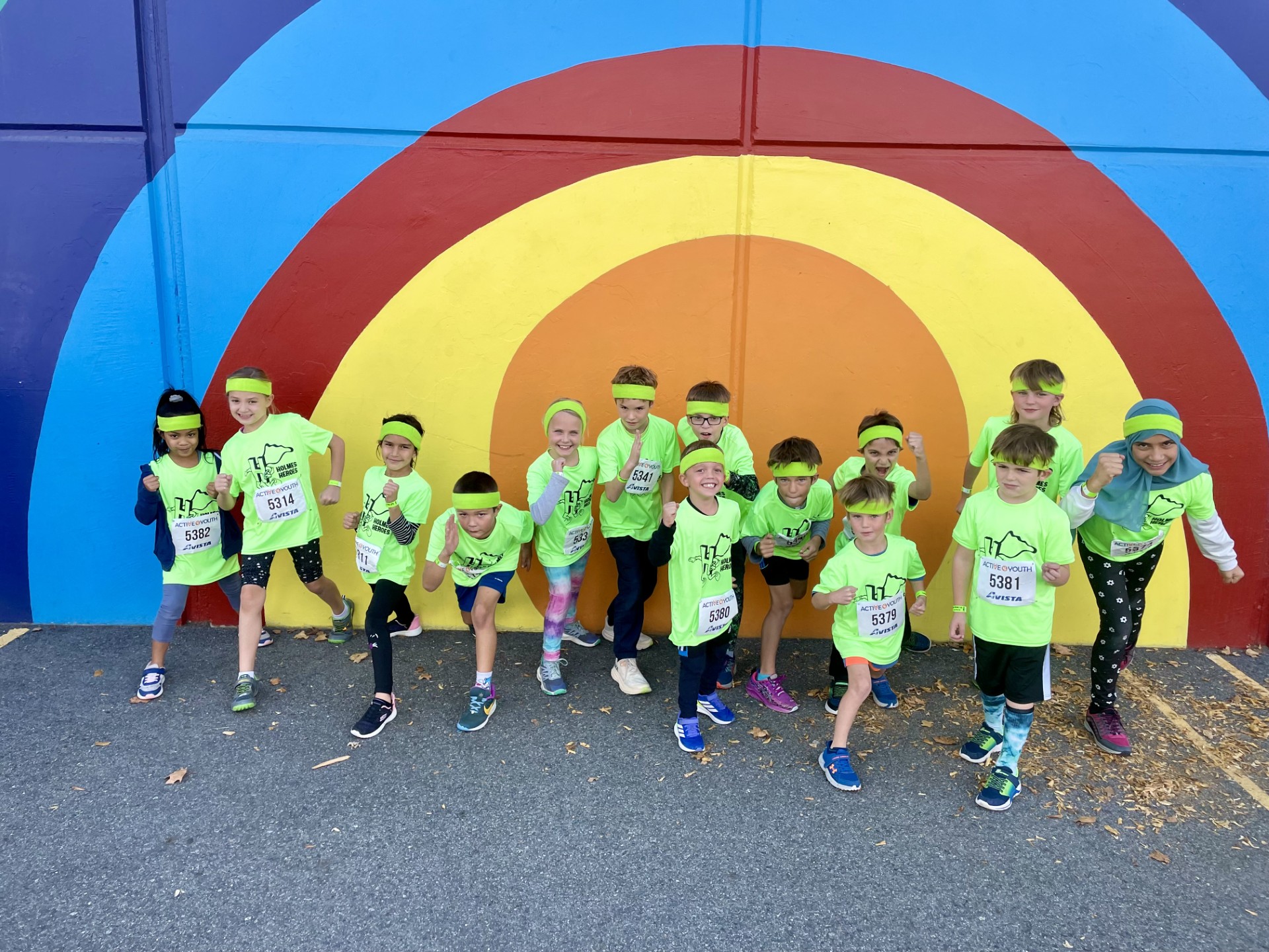 Cross Country runners in front of School rainbow