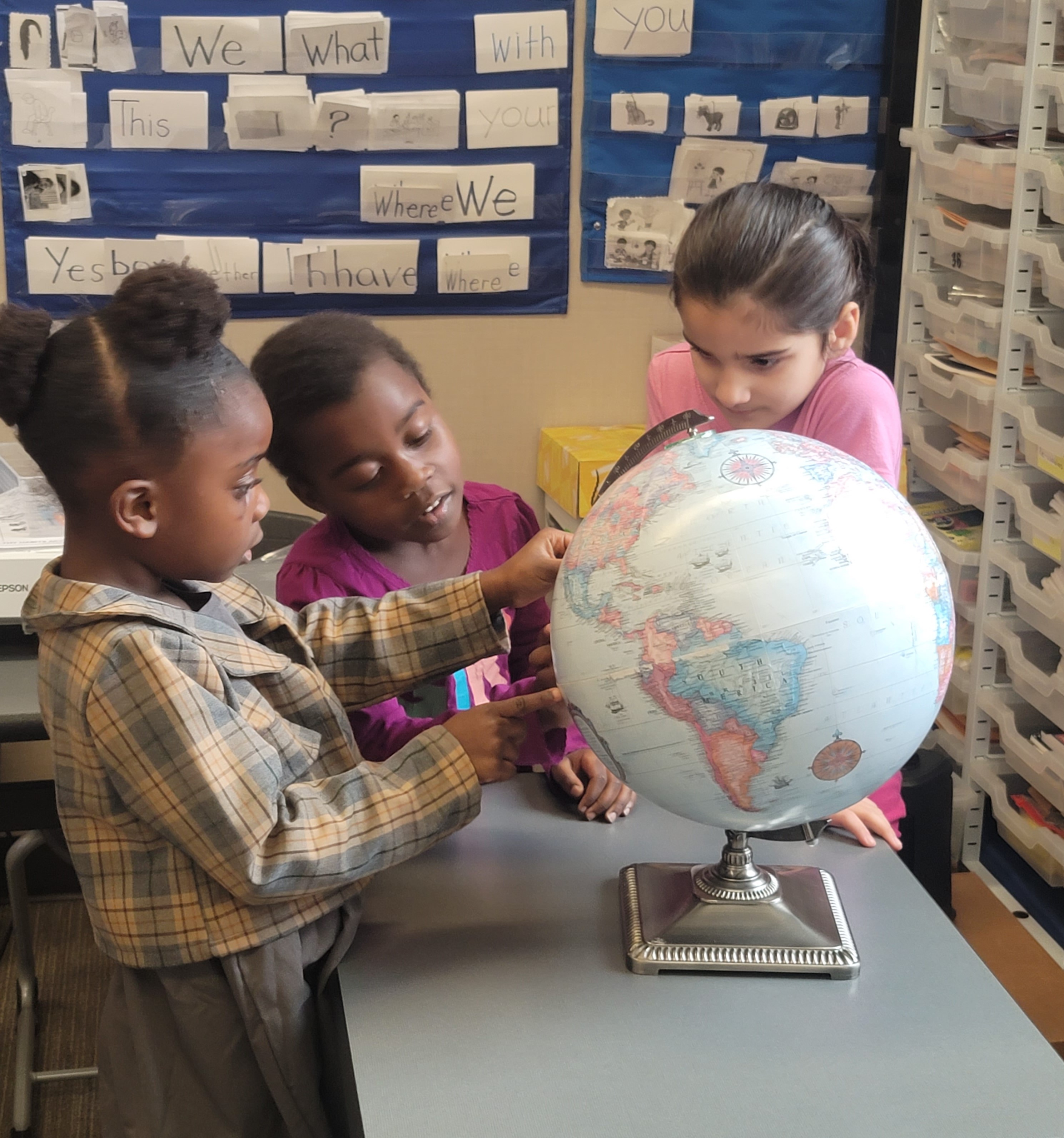 Kids looking at a globe