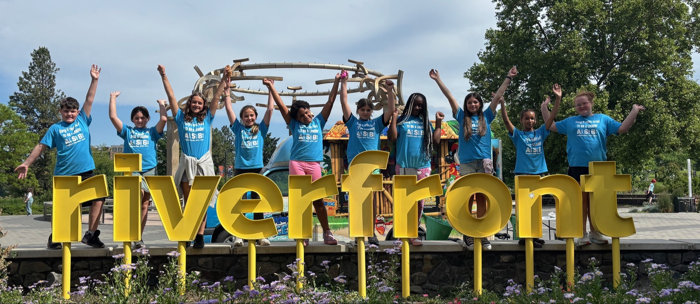 Cheer group in front of Riverfront Park sign