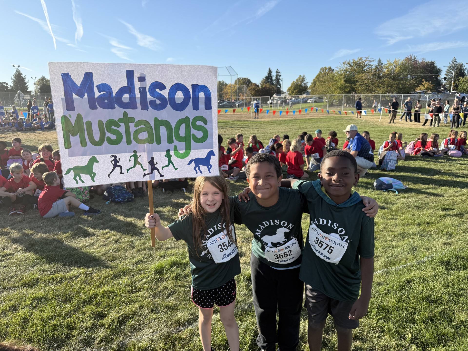 Madison Cross Country runners holding a Madison sign