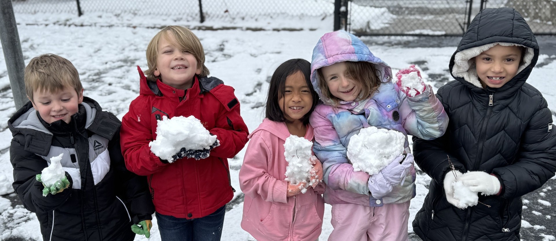 1st grade students holding snow balls
