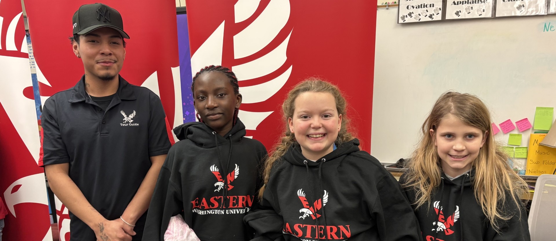 Madison students with Eastern Washington University student getting EWU sweatshirt as part of the Hoodie Project