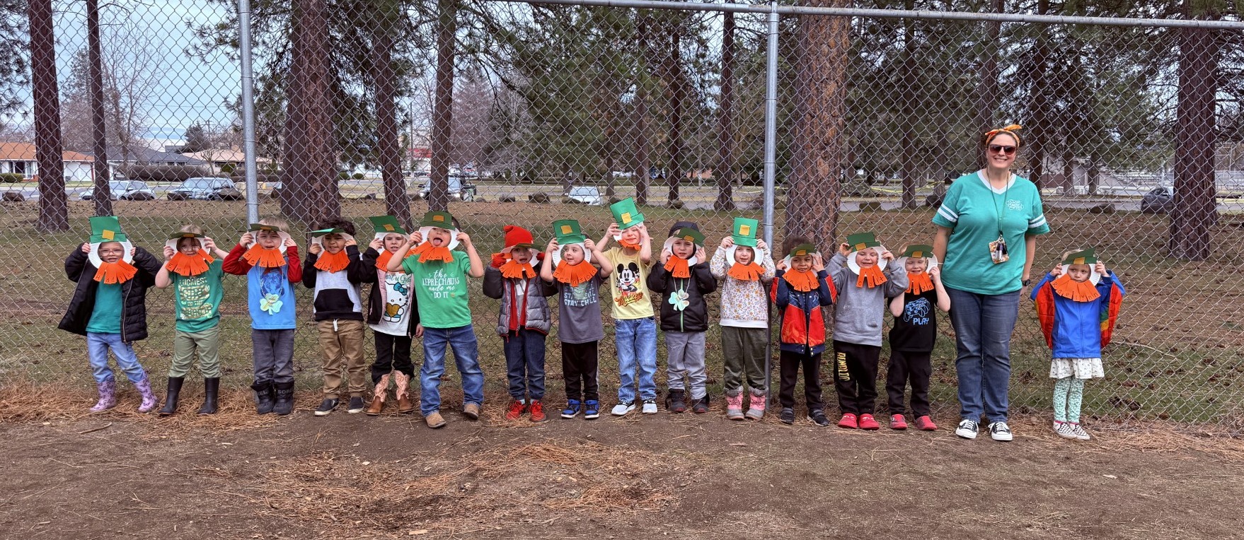 Preschool students and teacher wearing leprechaun masks