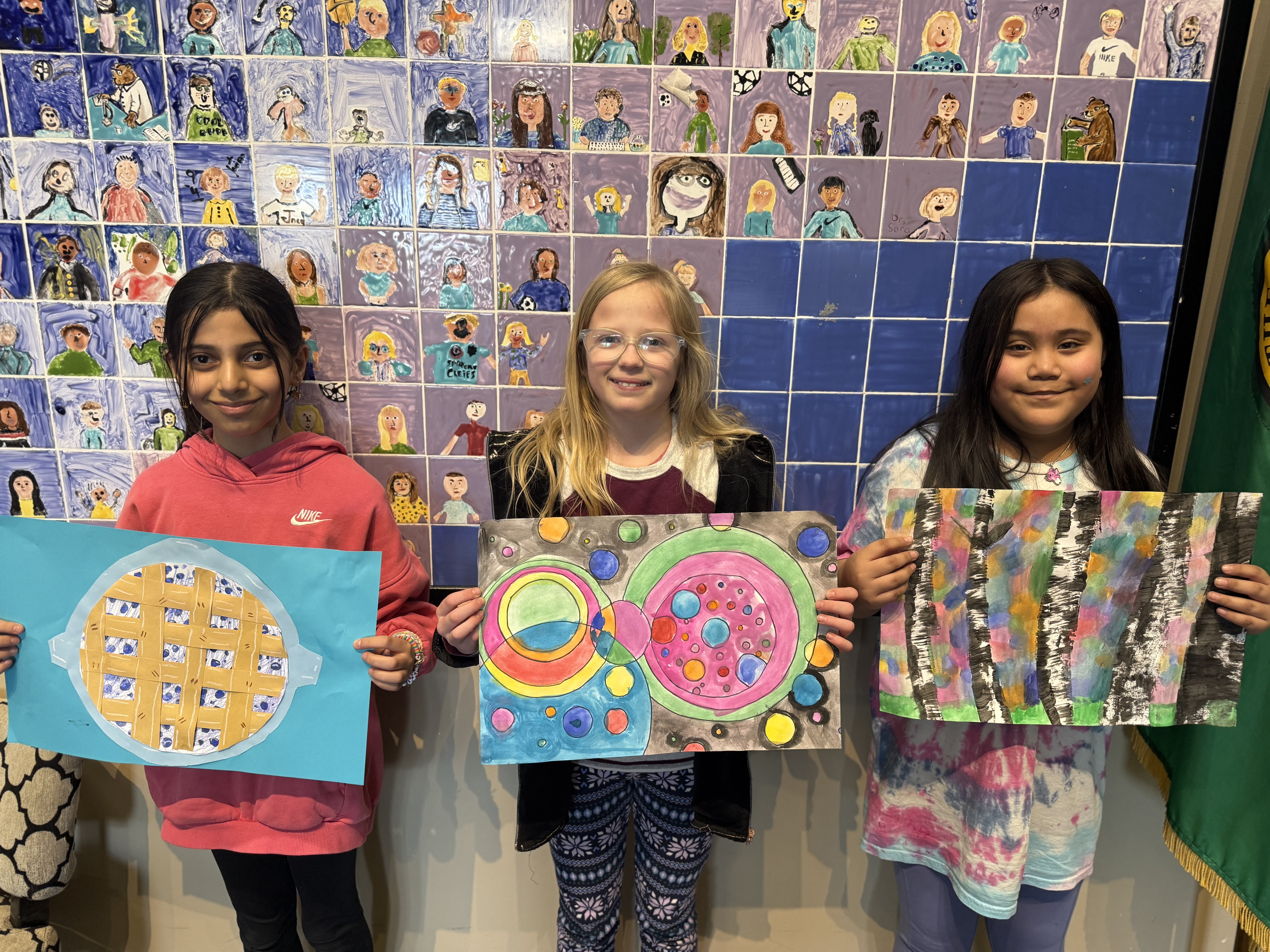 students hold artwork