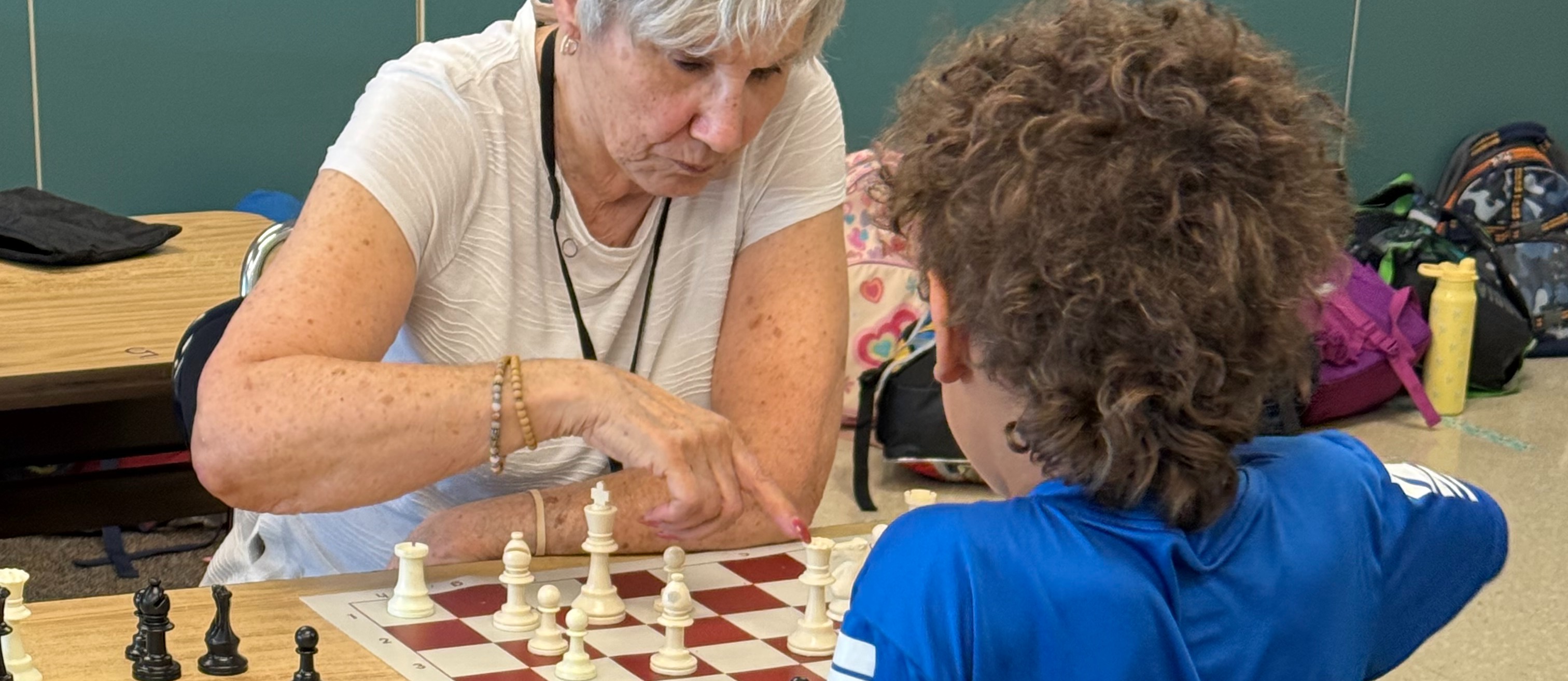 Student playing chess against coach