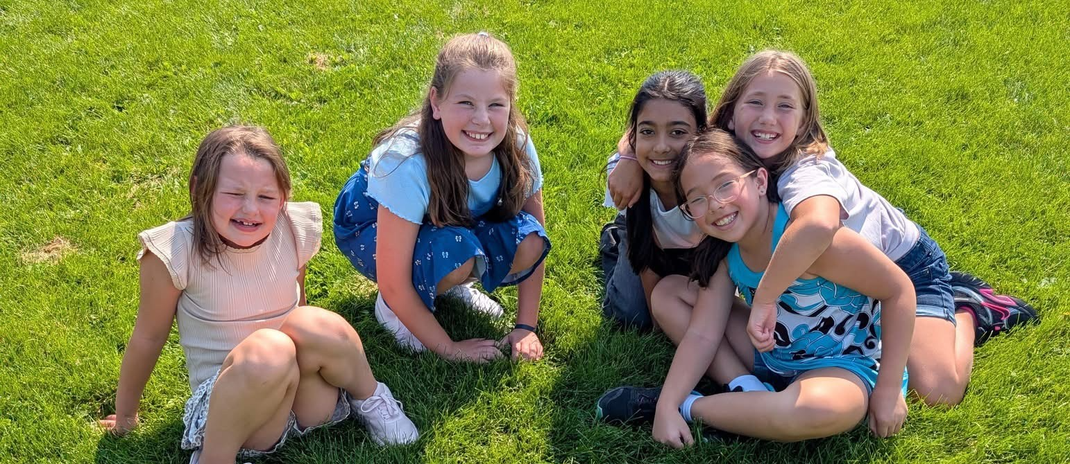 kids outside sitting on the grass