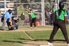 one girl batting and one girl getting ready to run from first base