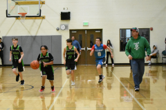 team running down the court, one dribbling