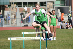 boy jumping over a hurdle