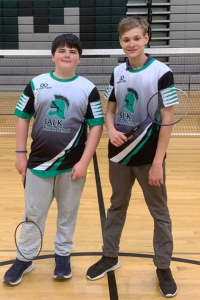 2 boys standing with racquets