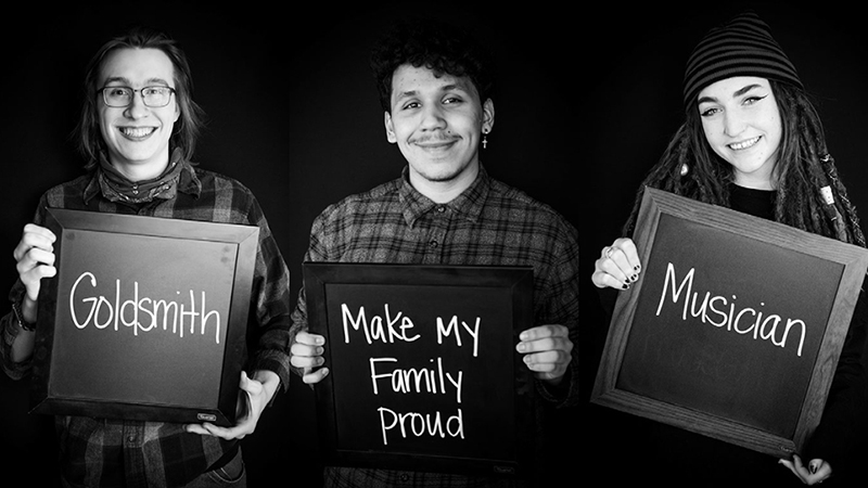 students holding a black board