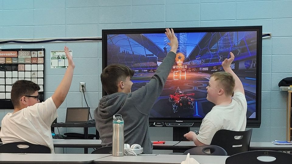 3 students celebrating playing an e-game
