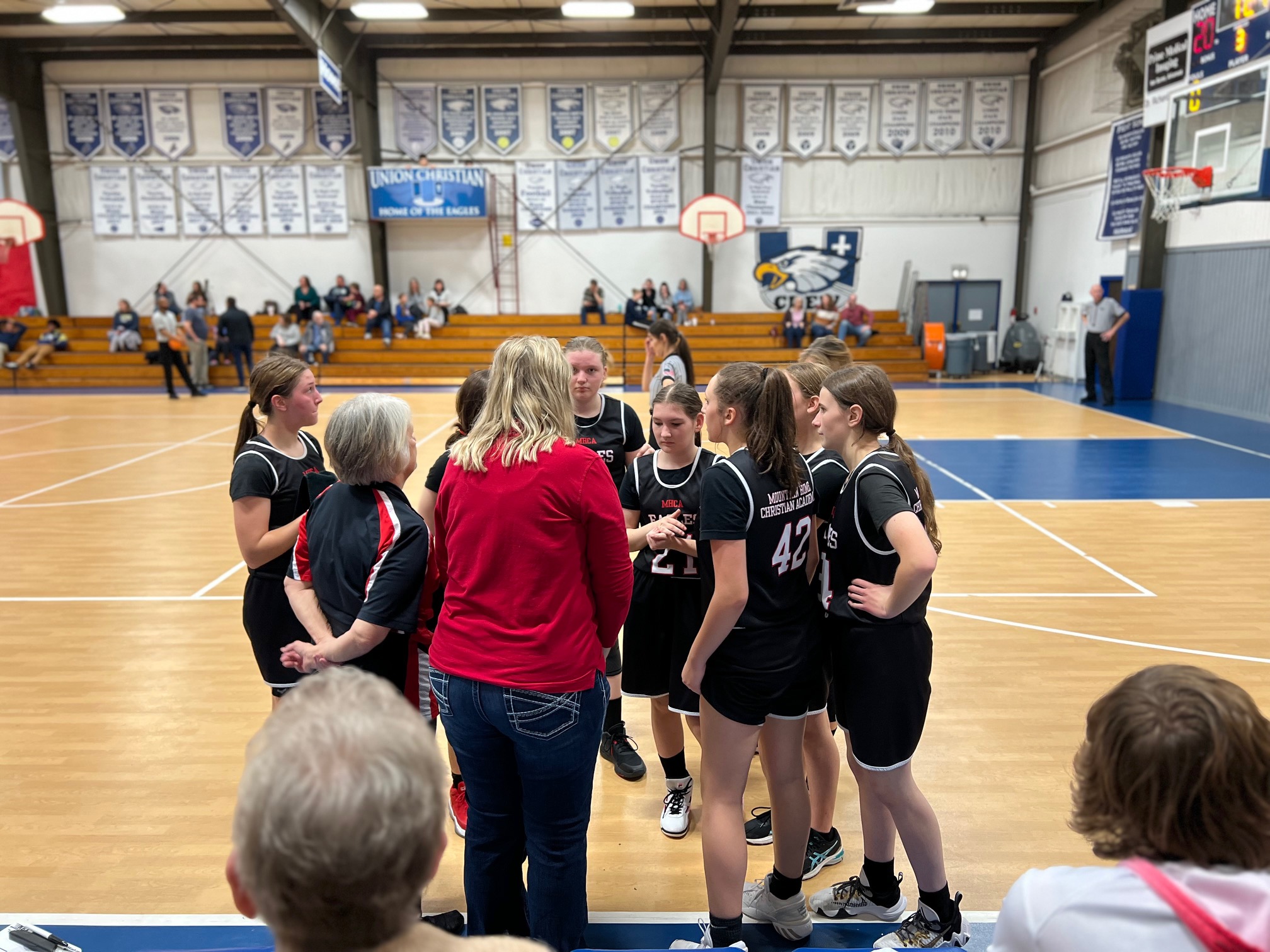 girls huddled around their coach