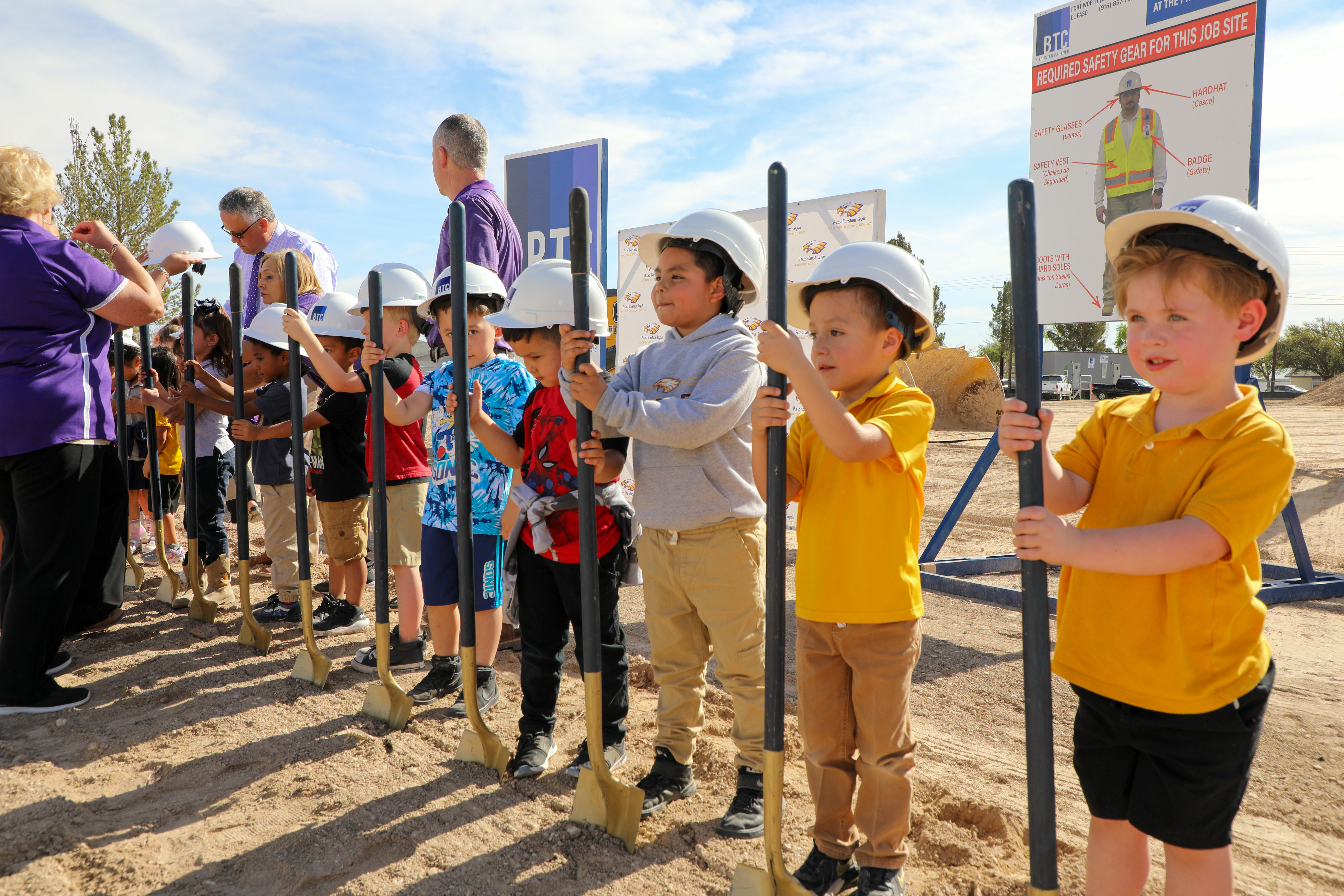 students in hard hats holding shovels at groundbreaking