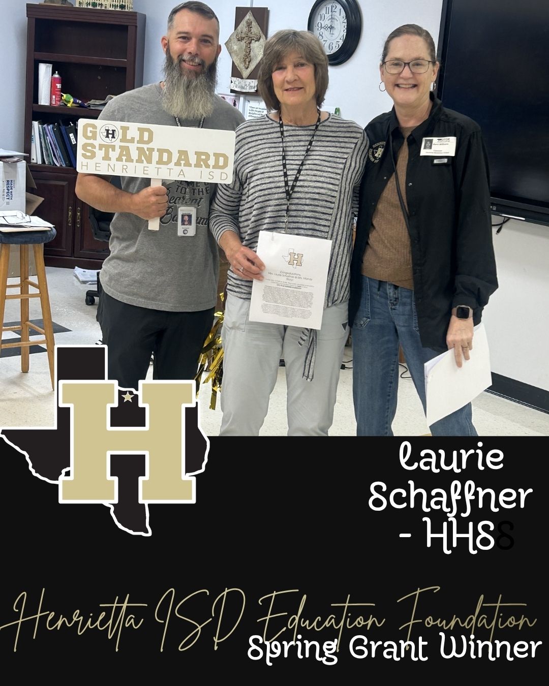 Three individuals stand in a room with a sign, one holding a paper, one holding a certificate, and one with glasses.