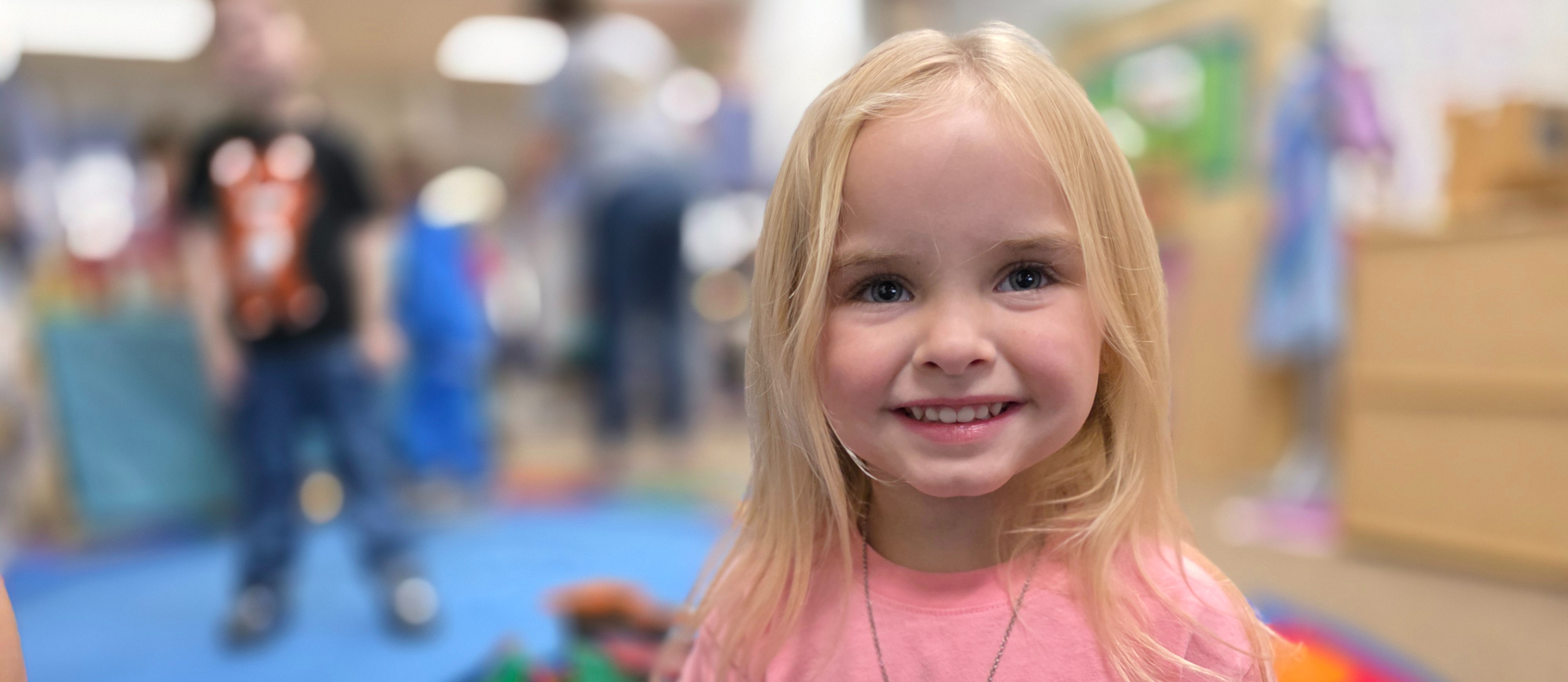 preschool student smiling in classroom.