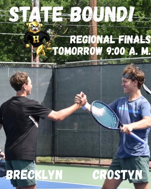Two tennis players shake hands. One holds a tennis racket, and they wear matching uniforms. The background features a fence and a mascot.