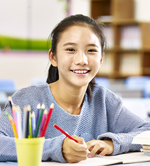 Girl smiling while writing on notebook