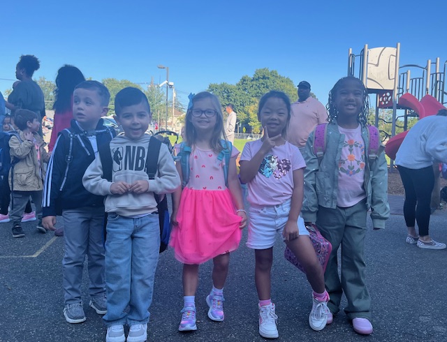 students on blacktop with backpacks