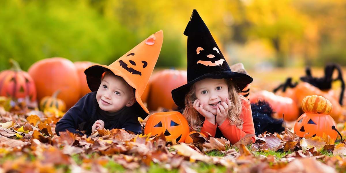 Toddlers dressed up like witches in pumpkin patch