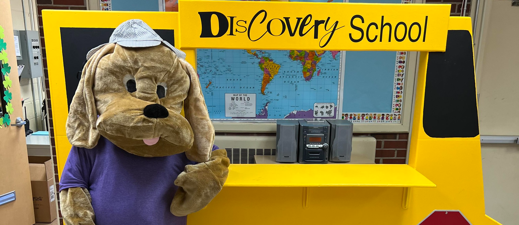 Mascot in front of school bus in office