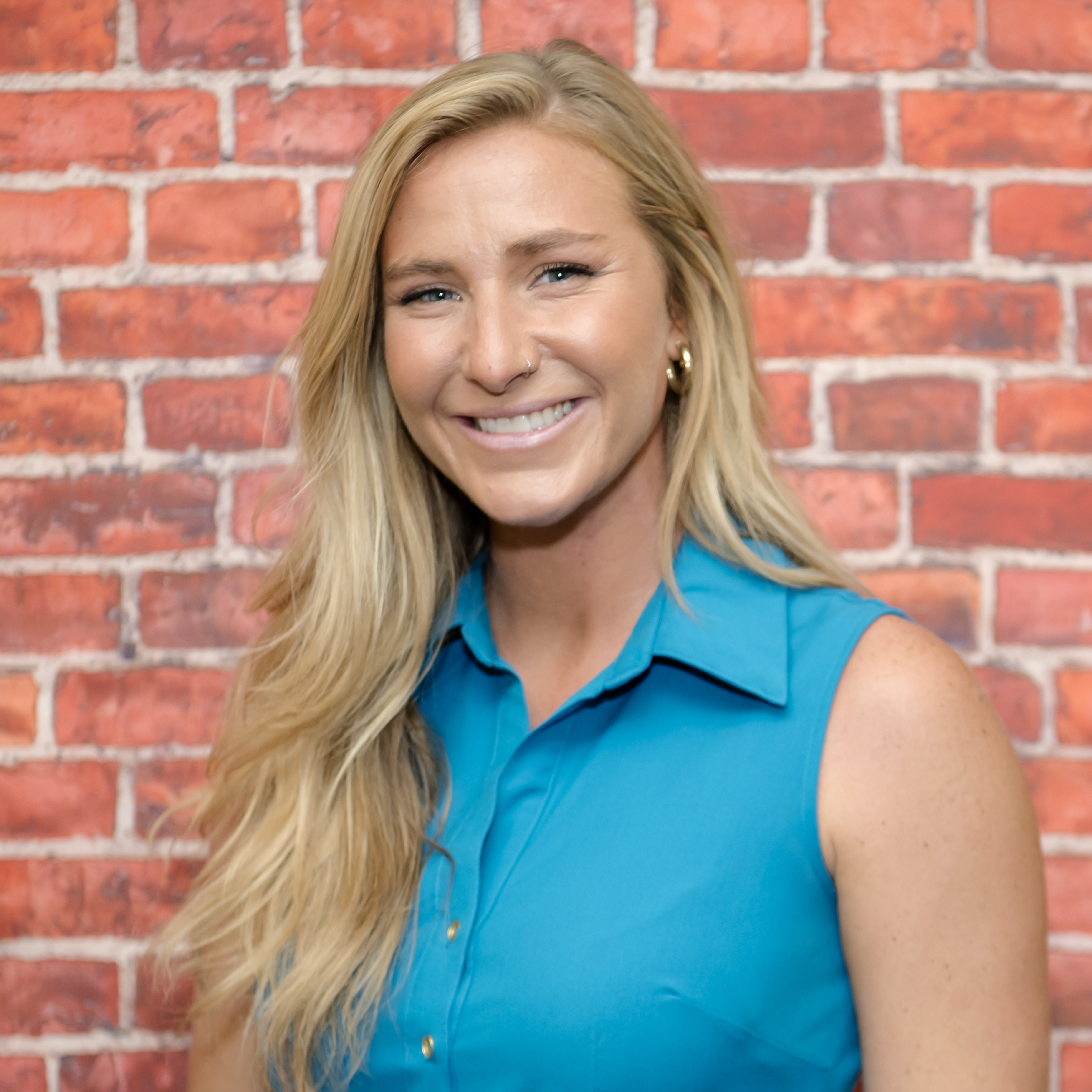 Photo of Mrs. Foster in front of a brick wall