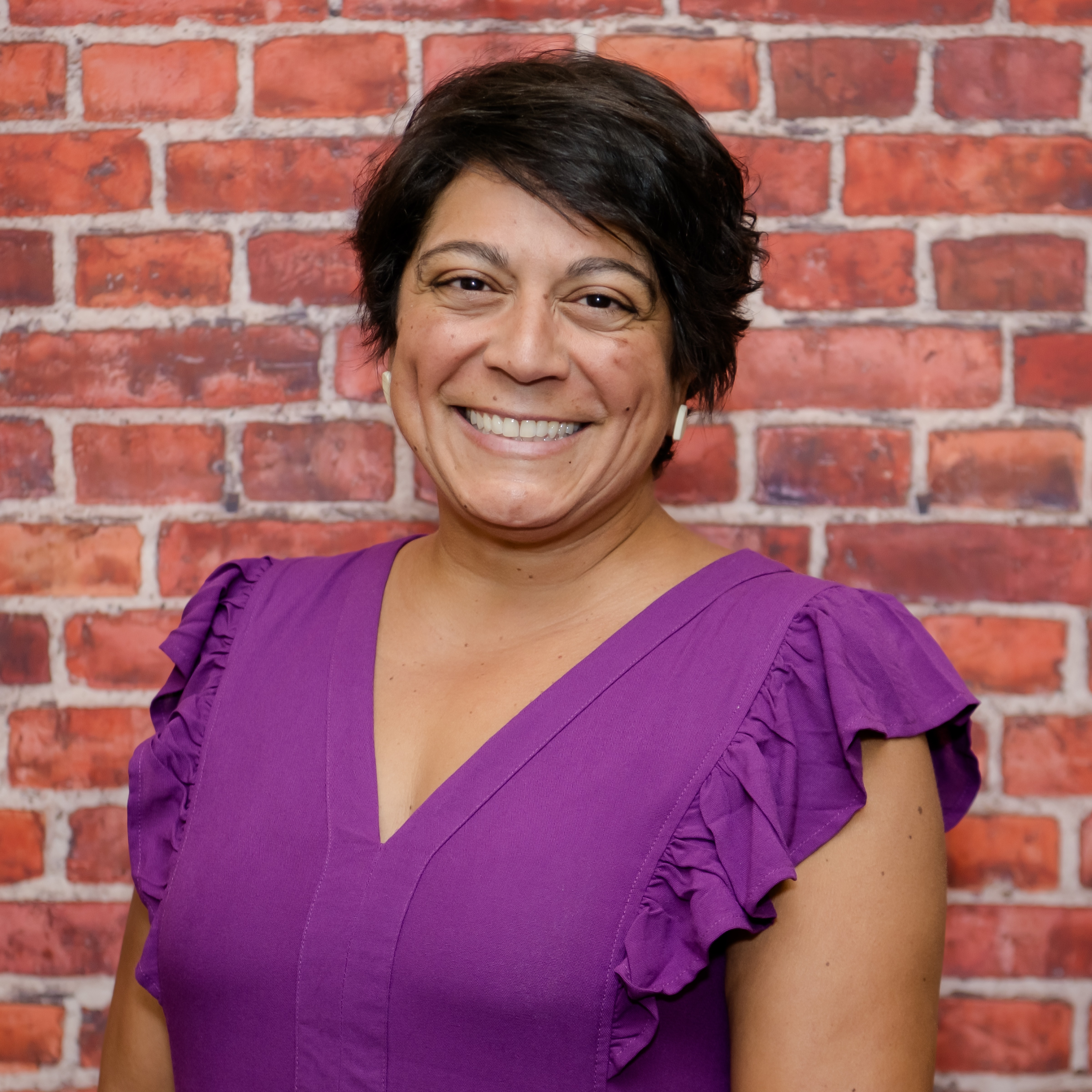 Photo of Mrs. Walton in front of a brick wall