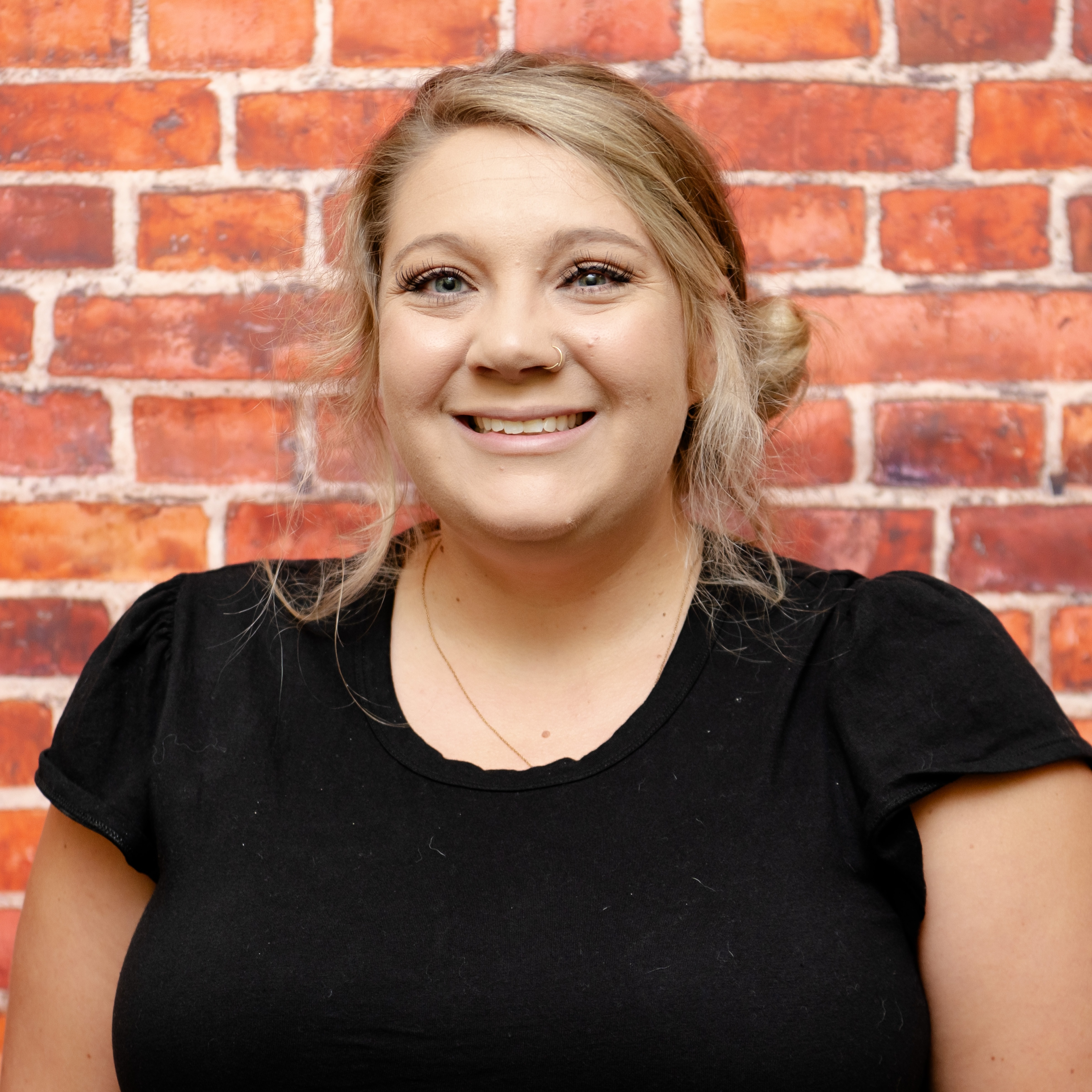 Photo of Mrs. Marks in front of a brick wall