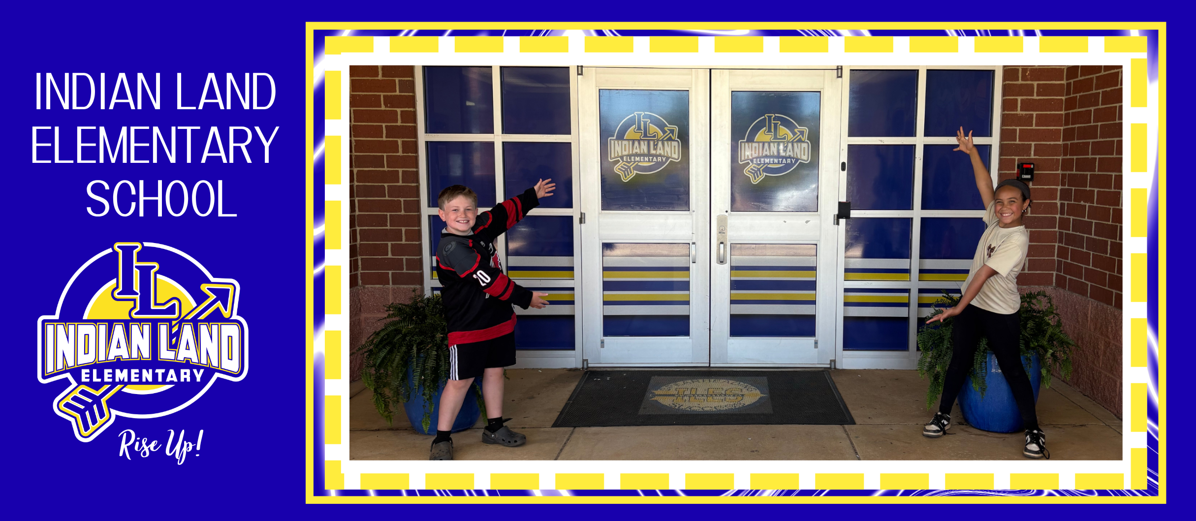 Two children pose in front of a brick building. A sign reads "Indian Land Elementary School" in the background.