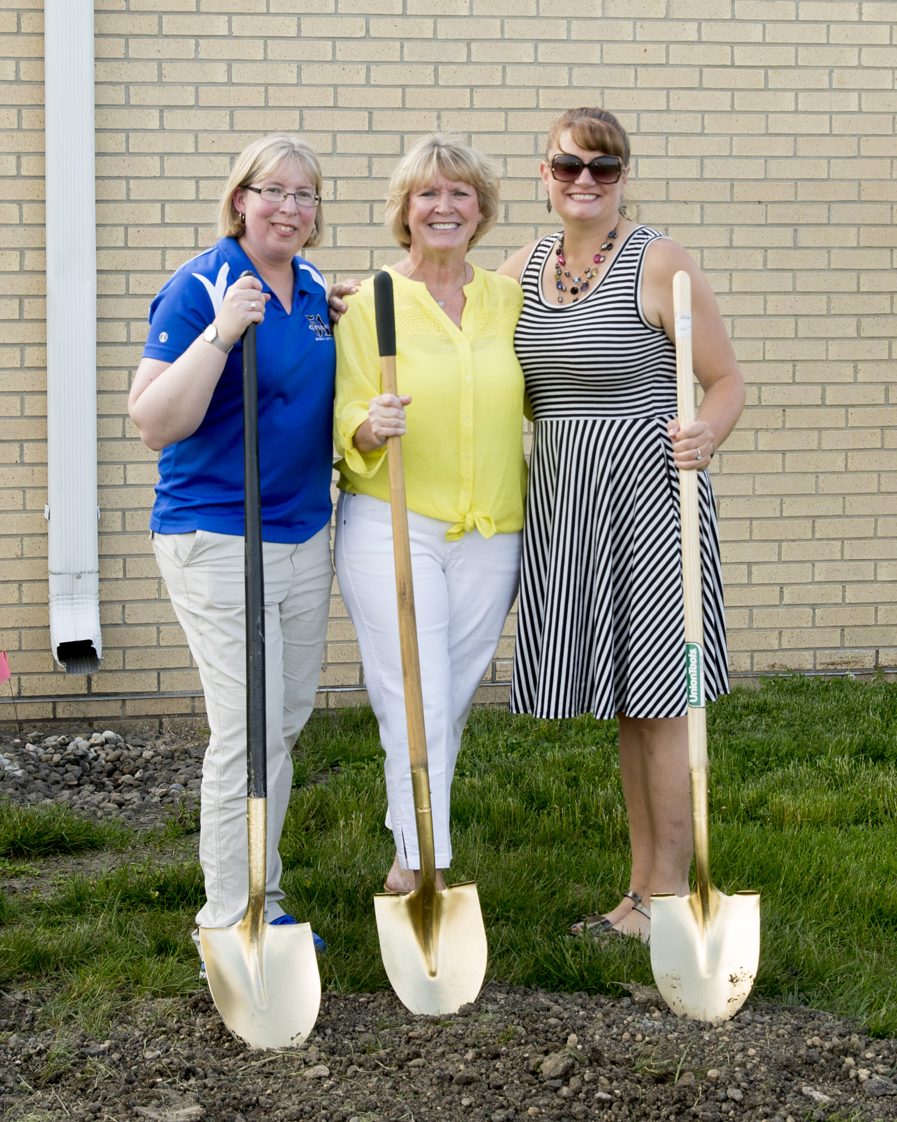 Members of the Board of Education posing the same as the teachers and with their own shovels.