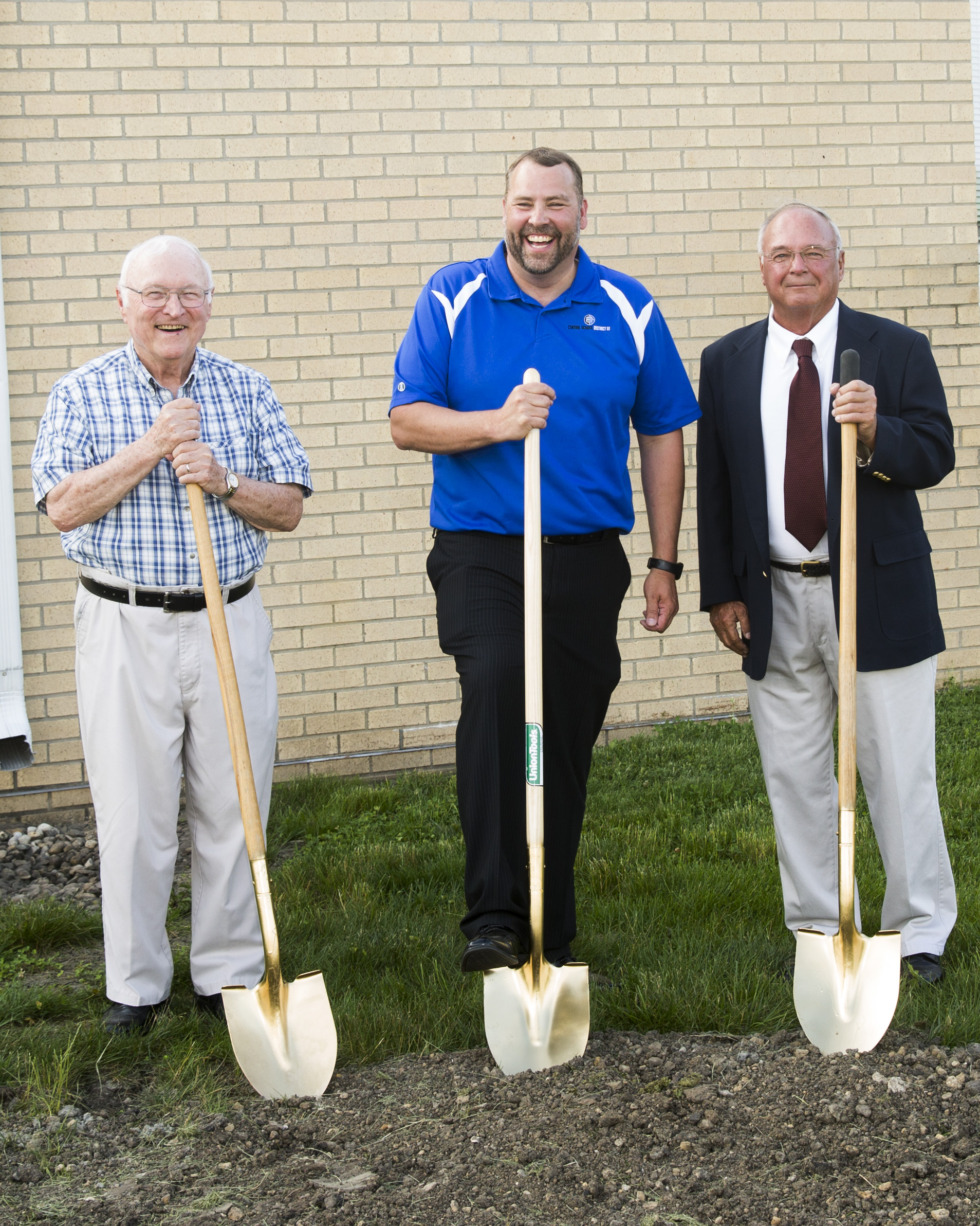 Members of the Board of Education posing the same as the teachers and with their own shovels.