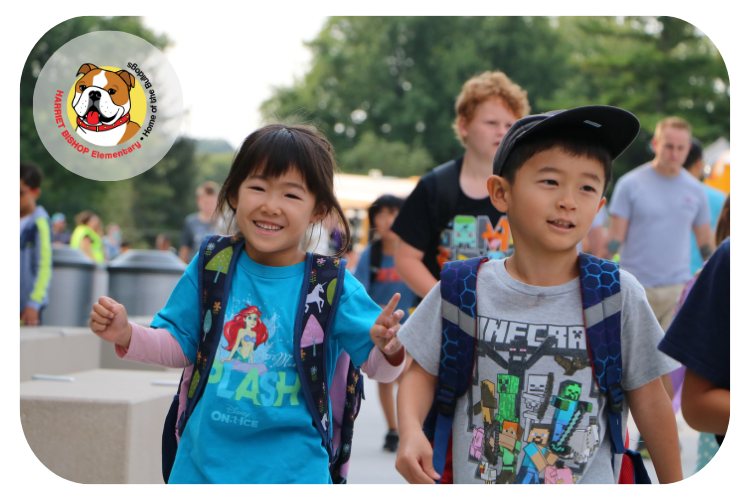 Two bishop students walking into school, one smiling at the camera.