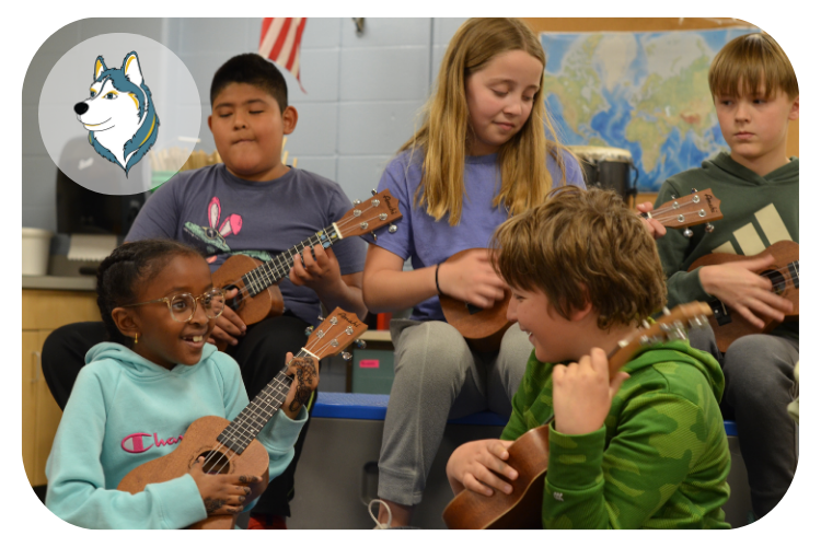 churchill hoover students playing the banjo while smiling at eachother.