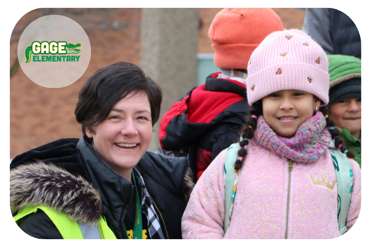 Julie McLaren, community school facilitator, standing next to a female student, both smiling at the camera.