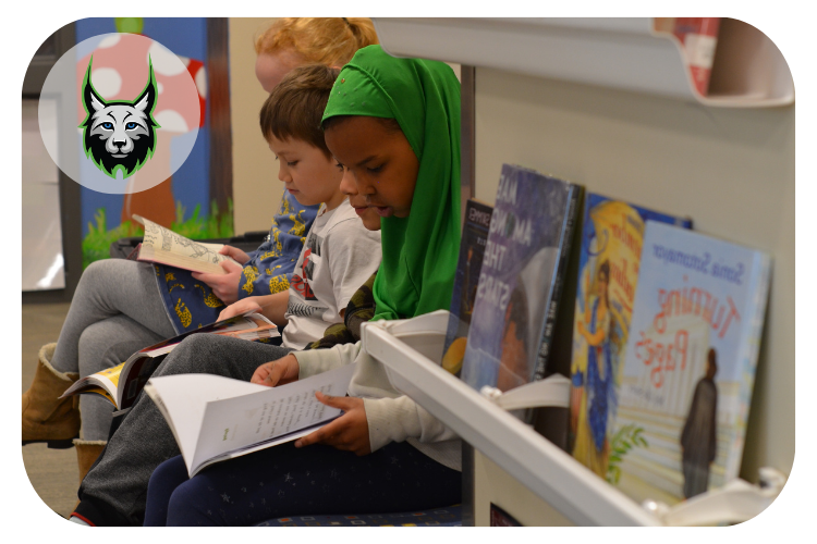 lincoln students reading quietly next to a bookshelf in the library.