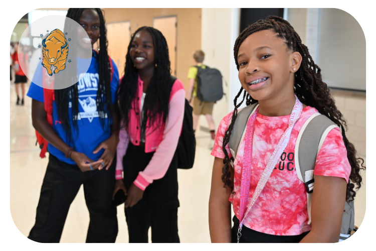 dakota middle school students smiling at the camera while leaving their locker space.