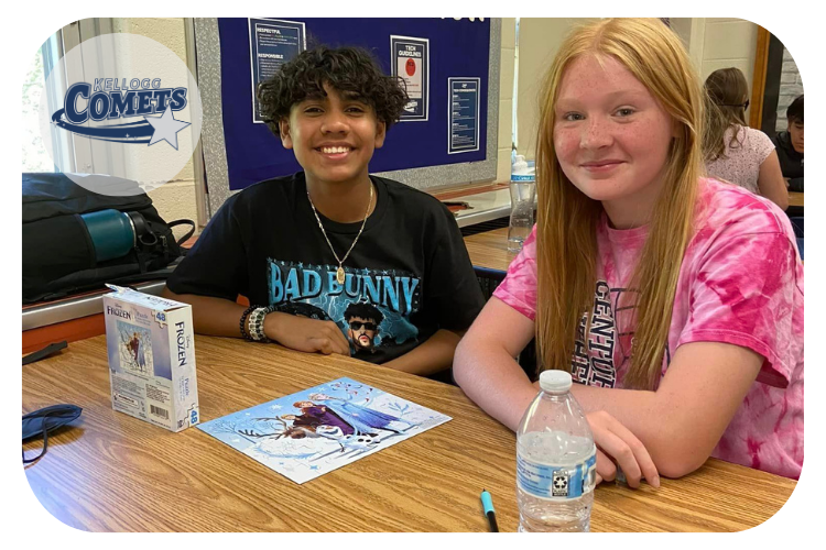 kellogg students showing off their finished puzzle and smiling at the camera.