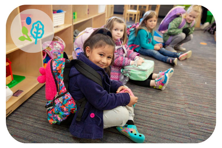 RPS preschool students in coats and bags as they wait for caregiver pick up in the classroom