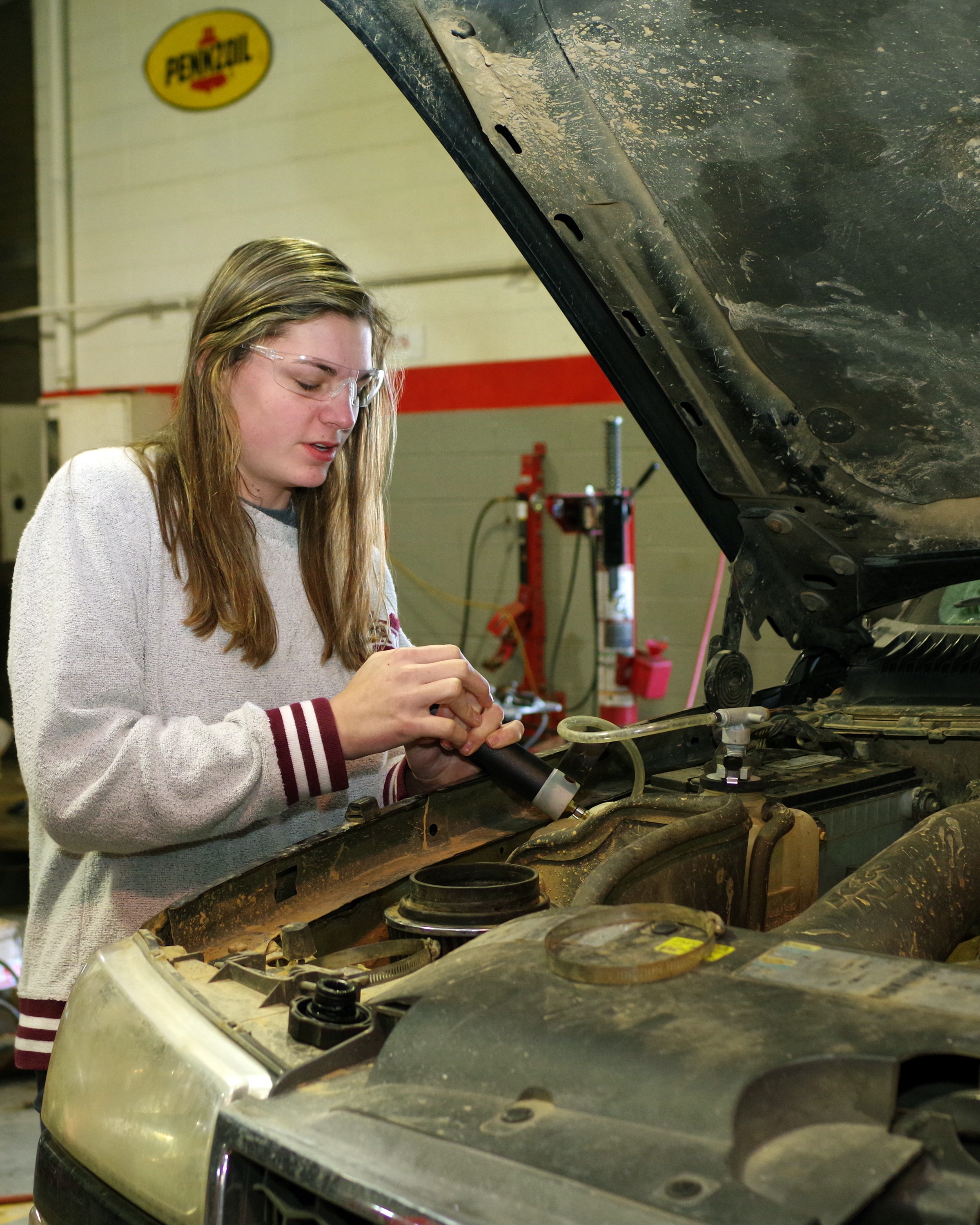 Female Student working on an older car